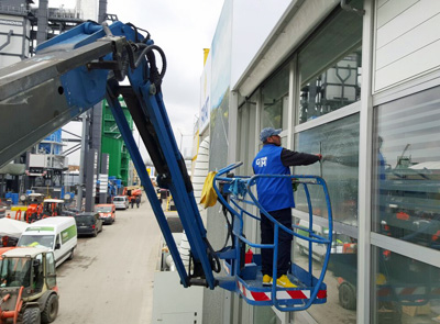 Gebäudereiniger bei der Glasreinigung auf Hubsteiger