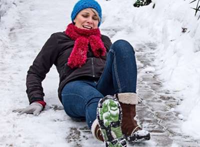 Frau rutscht auf Schnee aus